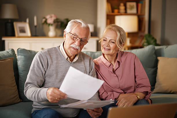 istock Senior couple reading documents at home, considering life insurance 2235884183