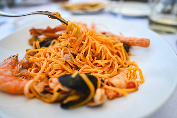 istock Fork lifting tasty linguine with seafood from plate 2235885657