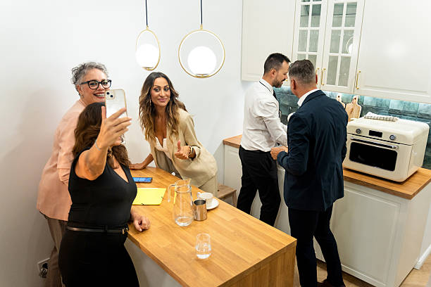 istock Businesswomen taking selfie in modern office kitchen during break 2235886037