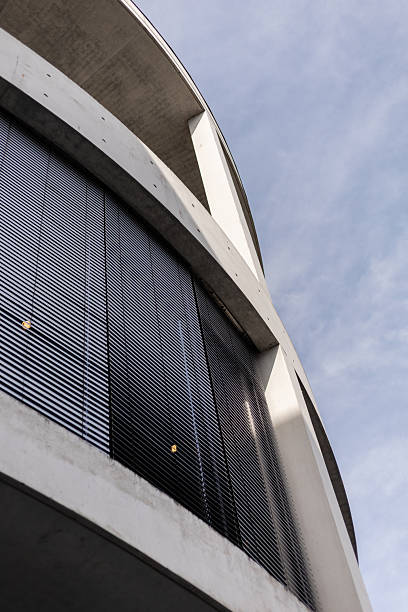 istock View of a contemporary building featuring black louvered panels and concrete structures, set against a bright sky. This scene showcases modern urban architecture in a vibrant city 2235887508