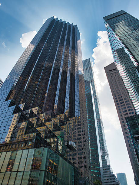 istock Modern Manhattan Skyscrapers from Below - A low-angle view of sleek, modern skyscrapers with reflective glass facades in New York City, creating a powerful urban perspective. 2235889099