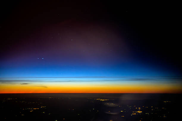 Flying over Spain, the sky changes from night to day as dawn brings a blend of stars and orange hues over the horizon.