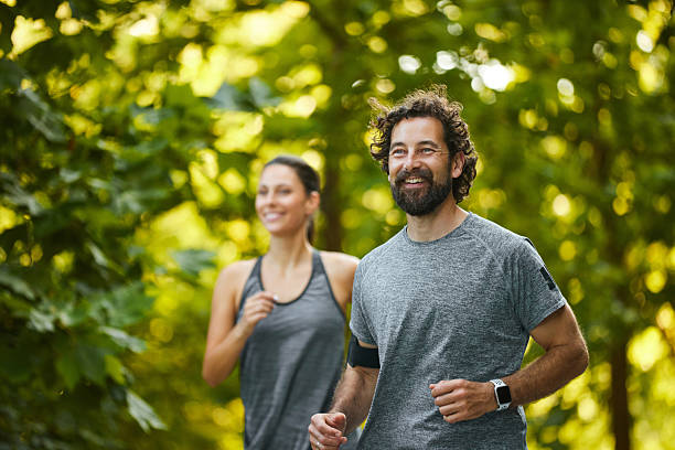 istock Couple jogging together in a green lush forest 2235891960