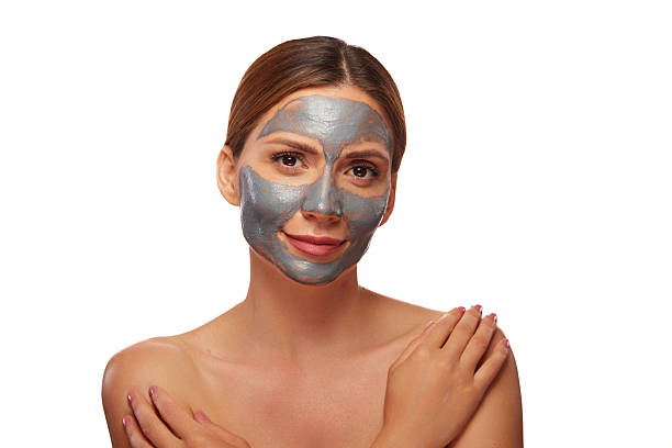 istock Young woman applying a purifying silver clay mask to her face 2235895787