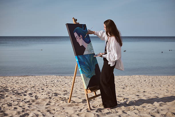 istock Young female painter creating art by seashore 2235895900