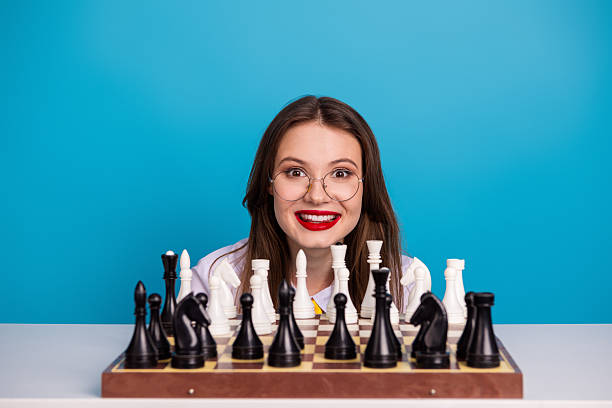 istock Young woman with a chessboard, blue background, symbolizing strategic thinking and skill. 2235897949