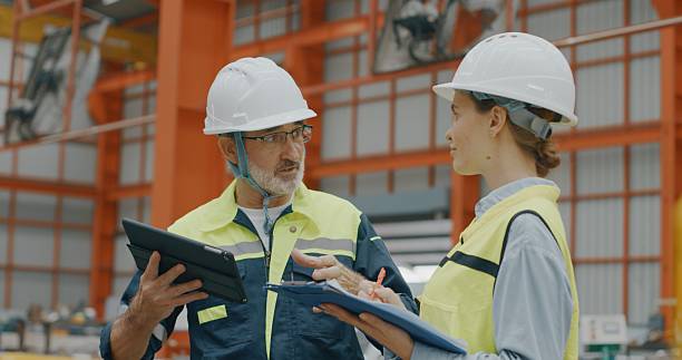 istock Male and female engineers with tablet and folder walking in warehouse 2235898972