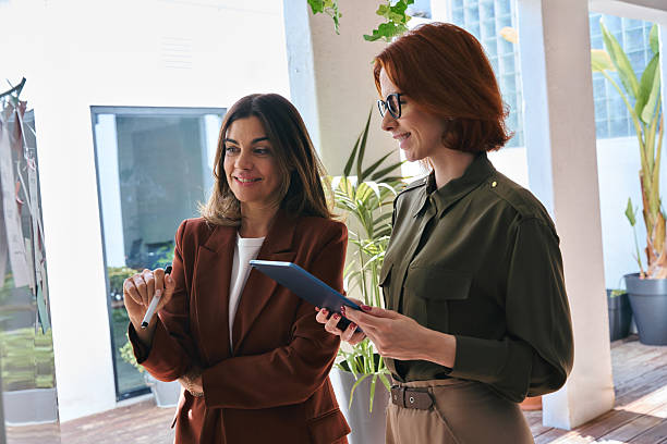 istock Two happy business women discussing sticky notes working together in office. 2235900768