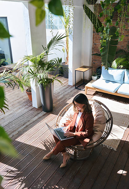 istock Middle aged business woman using laptop in sunny green office. Vertical. 2235900802