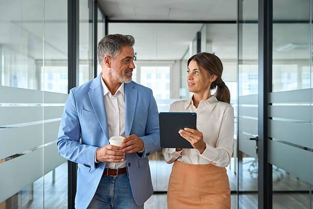 istock Two busy business people executives team talking walking in office. 2235903552