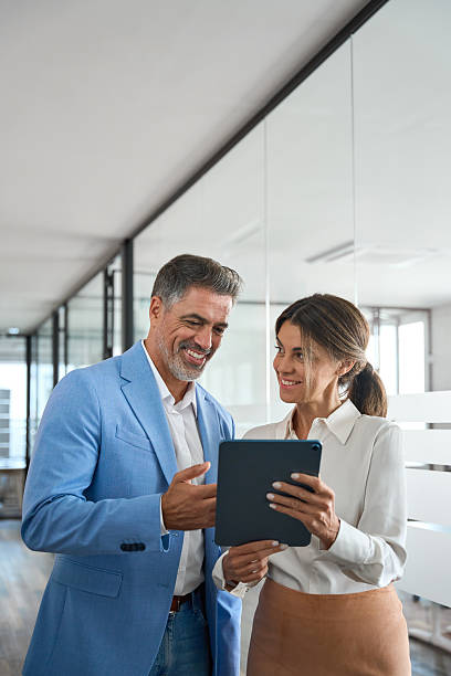 istock Two busy business man and woman executives team using tablet in office. 2235903568