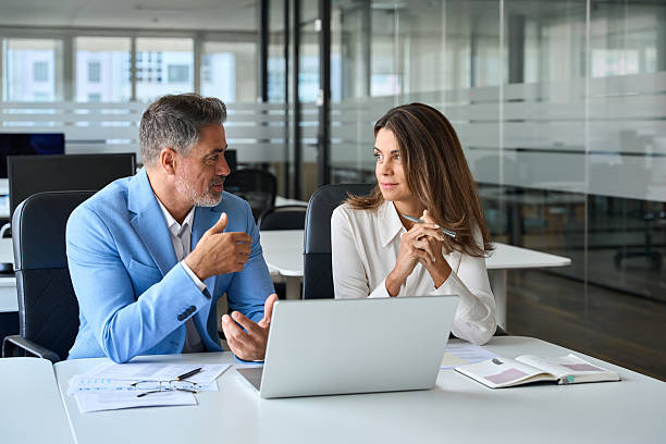 istock Business team of two busy professionals working together using laptop computer. 2235903598