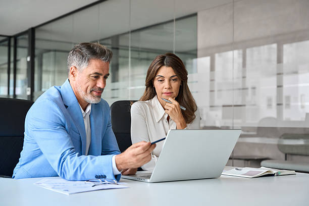istock Two busy business man and woman executives using laptop working in office. 2235903603