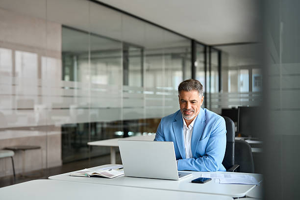 istock Happy senior older professional business man using computer working at desk. 2235903631