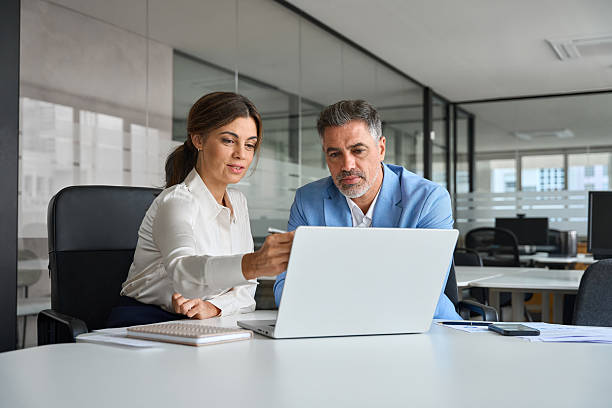 istock Two executives team business people working on laptop in corporate office. 2235903634