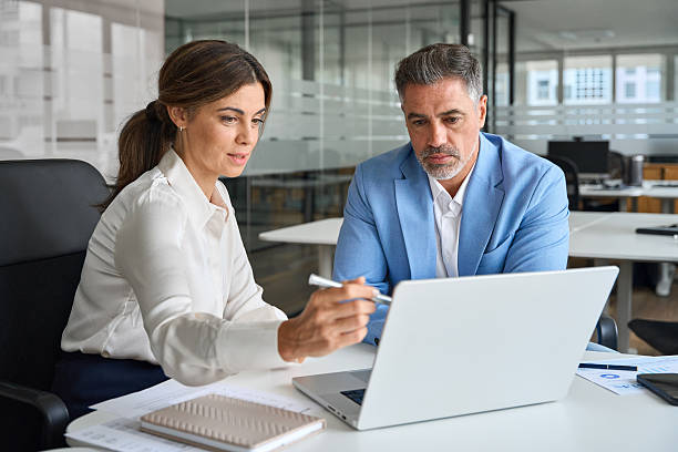 istock Female executive or bank manager consulting client using laptop in office. 2235903673