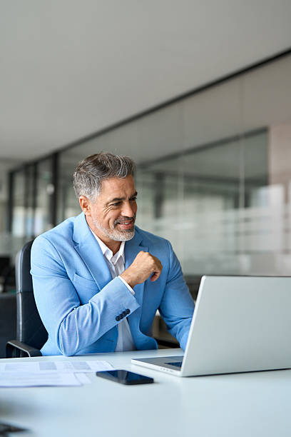 istock Busy middle aged professional businessman using laptop working at desk. Vertical 2235903697