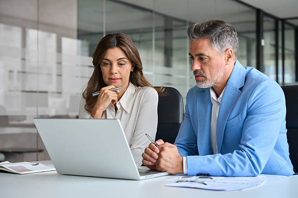 istock Business team of two busy professionals working together using laptop computer. 2235903714