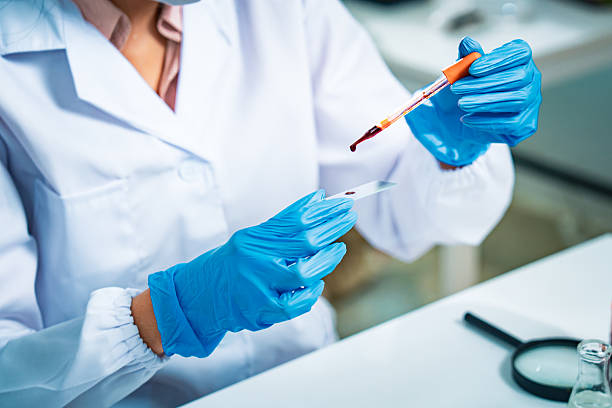 istock Female scientist in protective mask and gloves analyzing blood samples in test tubes inside a modern laboratory, symbolizing medical diagnostics, healthcare research, and scientific innovation. 2235903773