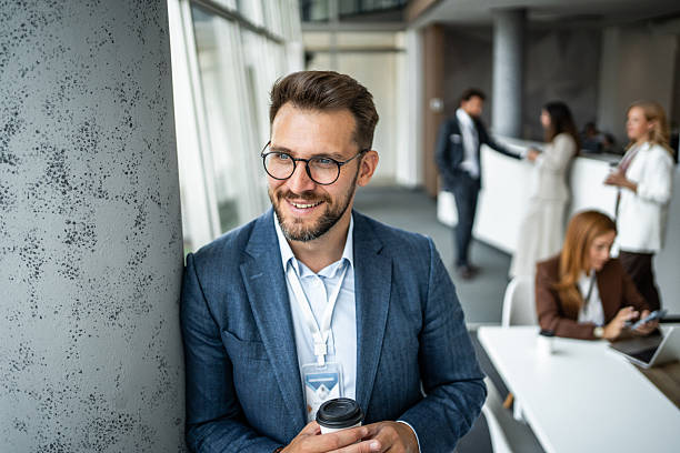 istock Businessman smiling during coffee break at conference 2235903823