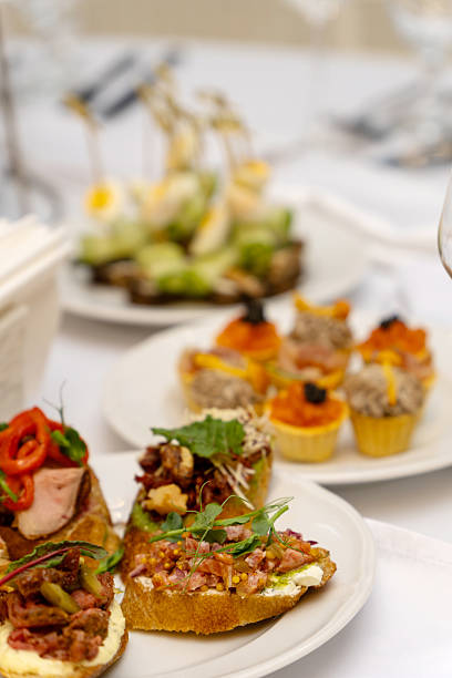 A beautifully arranged plate of assorted bruschetta, canapes, and marinated appetizers on a festive holiday table setting.