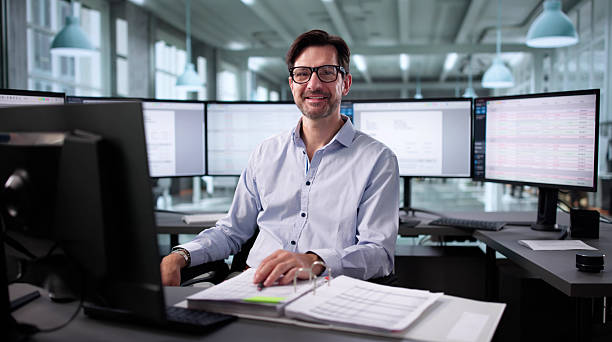 istock Smiling Accountant Crunching Numbers On Computer At Financial Office Desk 2235904921