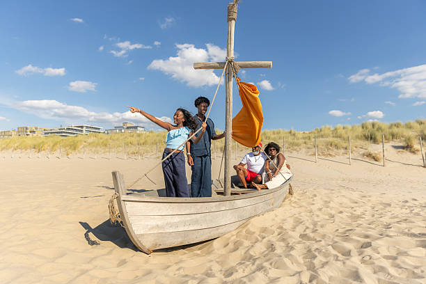 Tourists walk across a footbridge to the beach at St. Peter-Ording in North Frisia, with the seaside restaurant “Arche Noah” in the background.