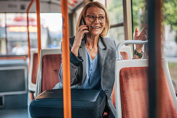 istock Smiling senior businesswoman talking on smartphone while riding bus 2235909731
