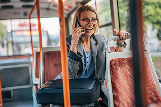 istock Excited businesswoman talking on phone while riding bus 2235909737