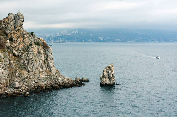 Rocks in blue sea water during a foggy day in the Italian Adriatic coast. Calming zen nature background