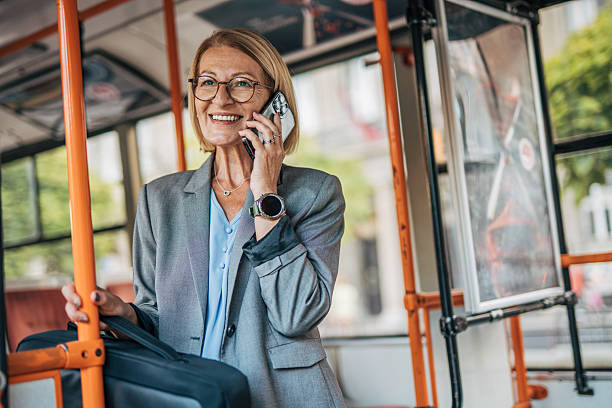istock Smiling senior businesswoman talking on phone while riding bus 2235909958