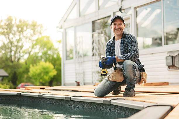 A Handyman worker making patio outside close to a pool