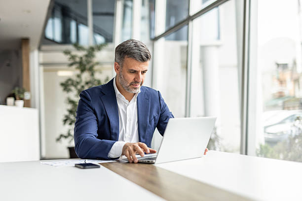 istock Businessman working on laptop in modern office 2235913111