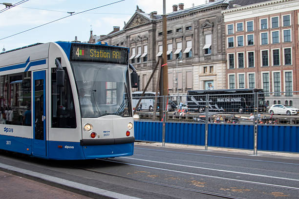 Amsterdam, Netherlands - Aug 20, 2016: A tram moving carrying passengers on a quiet street.