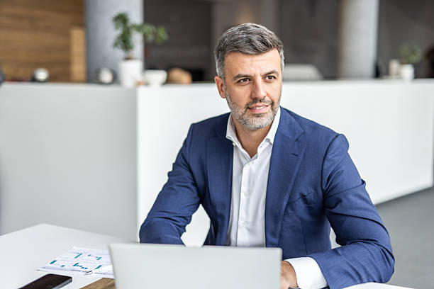 istock Confident businessman working on laptop in modern office 2235913171