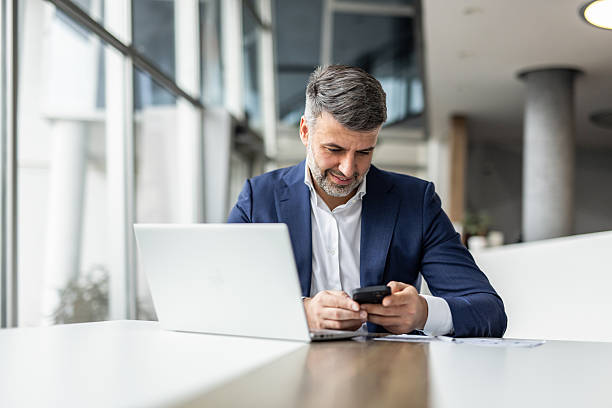 istock Businessman using smartphone and laptop in modern office 2235913174