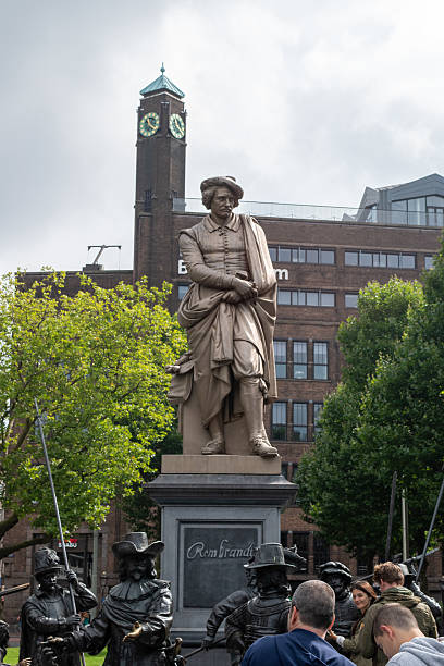 Amsterdam, Netherlands - Aug 20, 2016: A view of the Rembrandt monument with visitors in Amsterdam. The statue of Rembrandt was made in 1852 by sculptor Louis Royer and is of cast iron. It was cast in one piece and it is Amsterdam's oldest surviving statue in a public space.