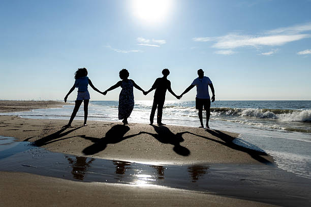 A beautiful diverse family made up of a mother, father and two children enjoying a sunny day on the beach in the Netherlands