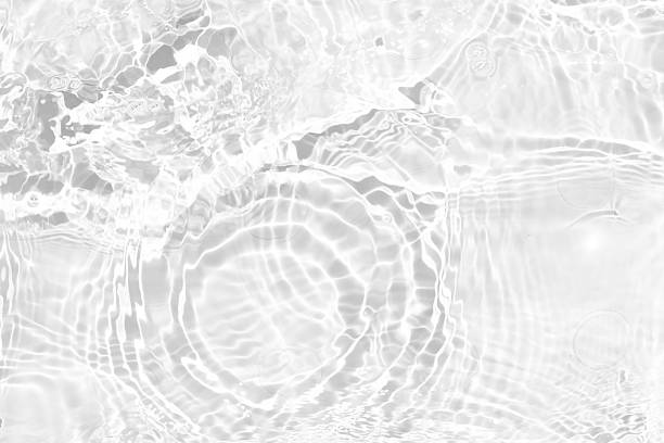 istock White water with ripples on the surface. Defocus blurred transparent white colored clear calm water surface texture with splashes and bubbles. Water waves with shining pattern texture background. 2235915870