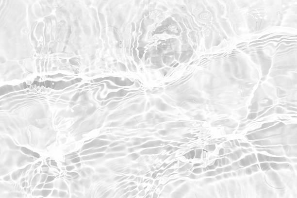 istock White water with ripples on the surface. Defocus blurred transparent white colored clear calm water surface texture with splashes and bubbles. Water waves with shining pattern texture background. 2235915887