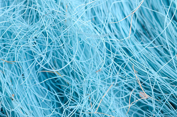 This abstract image showcases a dense, messy web of fine blue synthetic fibers, highlighting a vibrant and dynamic texture that fills the frame.