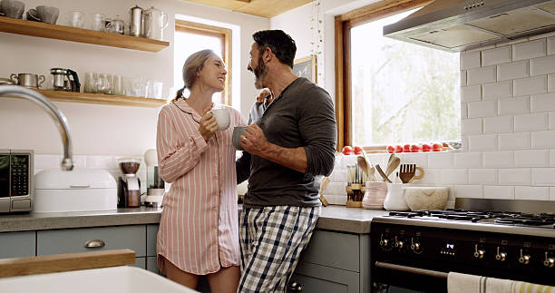 istock Laugh, smile and couple with coffee in kitchen for bonding, connection or conversation together. Love, drinking and man with woman for morning, caffeine beverage and communication or chat in home 2235917592