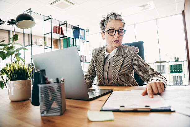 istock Professional businesswoman at work reviewing documents in a modern office environment with organized workspace and corporate resources 2235917646