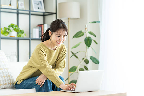 istock Young woman using a computer in the living room 2235917898