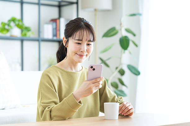 istock Young woman using a smartphone in the living room 2235917963