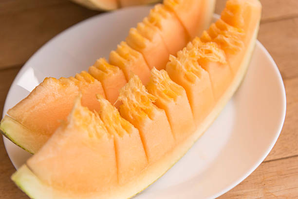use knife split the orange melon on wood plate