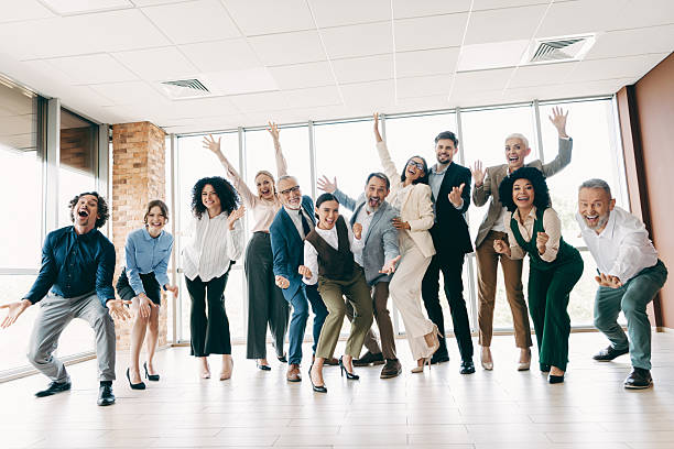 istock Dynamic group of professionals celebrating teamwork and success in a bright modern office setting 2235919740