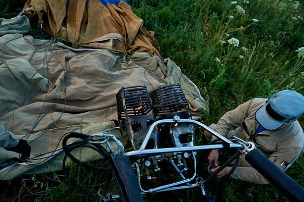 istock Man Operating Hot Air Balloon Burner on Grass Field 2235920793