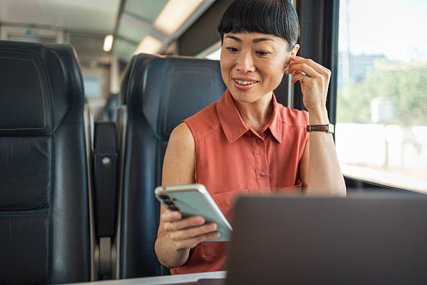 istock Businesswoman working on train using laptop and smartphone 2235924447