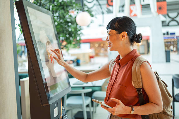 istock Customer ordering food using self-service kiosk in restaurant 2235924453